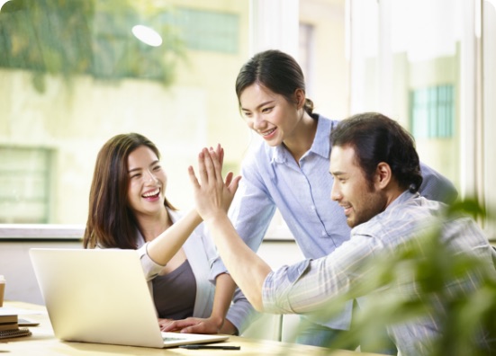 Business partners high-fiving across their desks